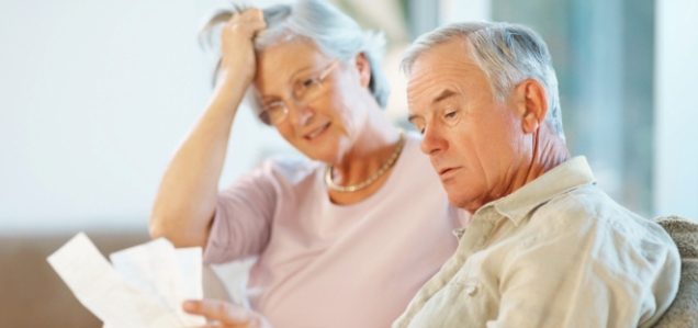 Distressed elderly couple reading paperwork